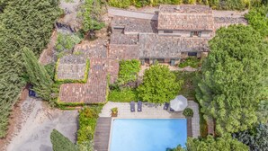 An aerial view of a residential area with multiple houses, a swimming pool, and surrounding greenery. - Charming stone house with airco and a large pool (Lorgues)