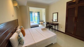 A hotel room with a bed, a desk, a chair, and a wardrobe.