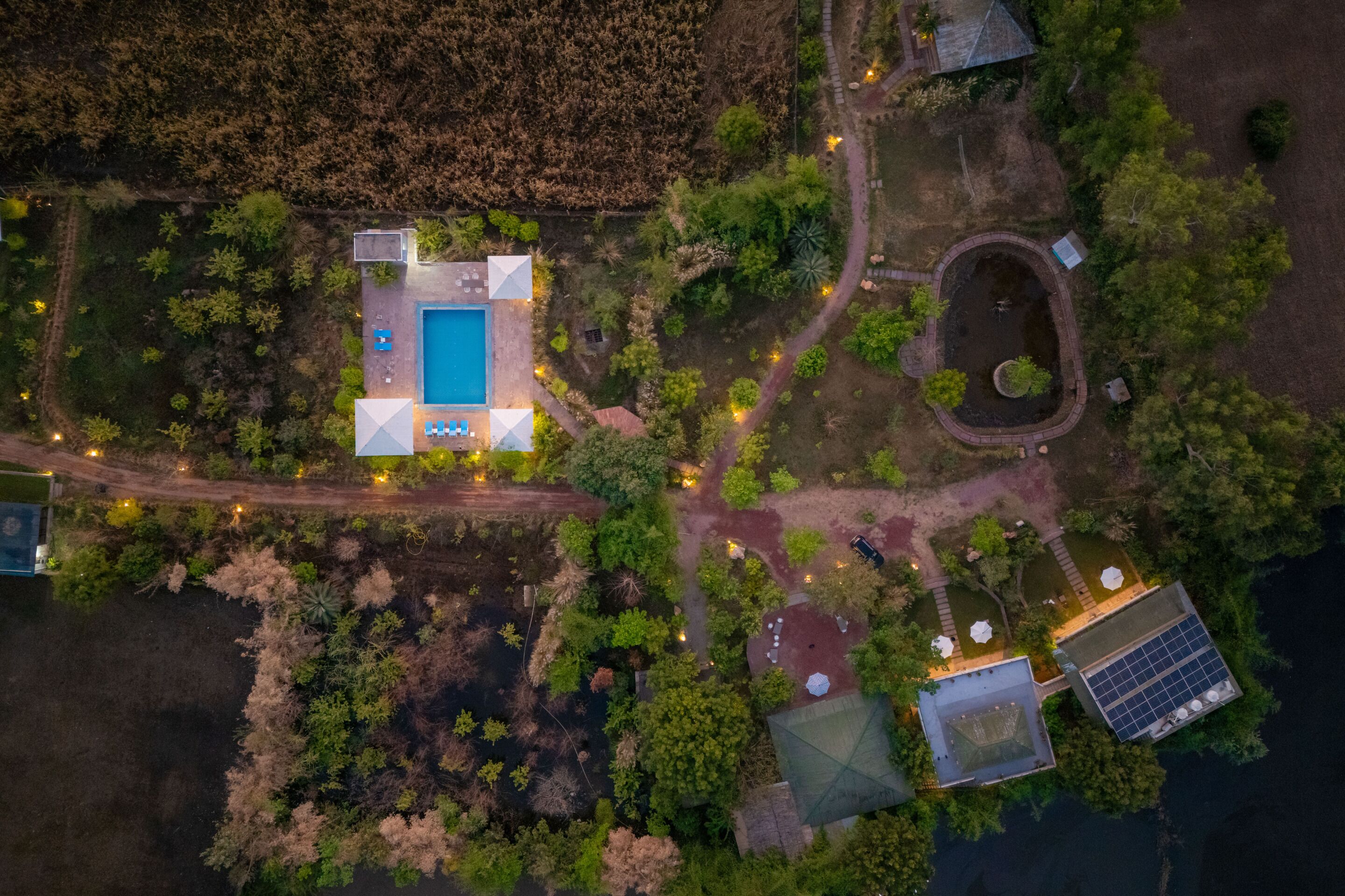 Luchtbeeld van een bezit met een zwembad, zonnepanelen en een ronde tuin.