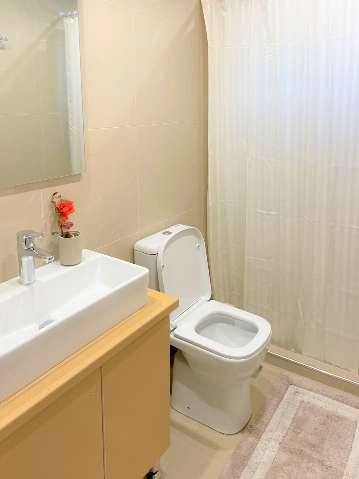 Ein Badezimmer mit einem weißen Waschbecken, einer Toilette und einem Spiegel.