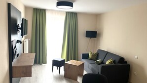A modern living room with a sofa, a coffee table, a TV, and a floor lamp.