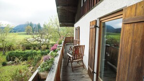 A wooden deck with a view of a green landscape and mountains.