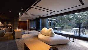 A modern interior with a large window, a sofa, a wooden bench, and a small table. - Sengokubara cocon (Hakone)
