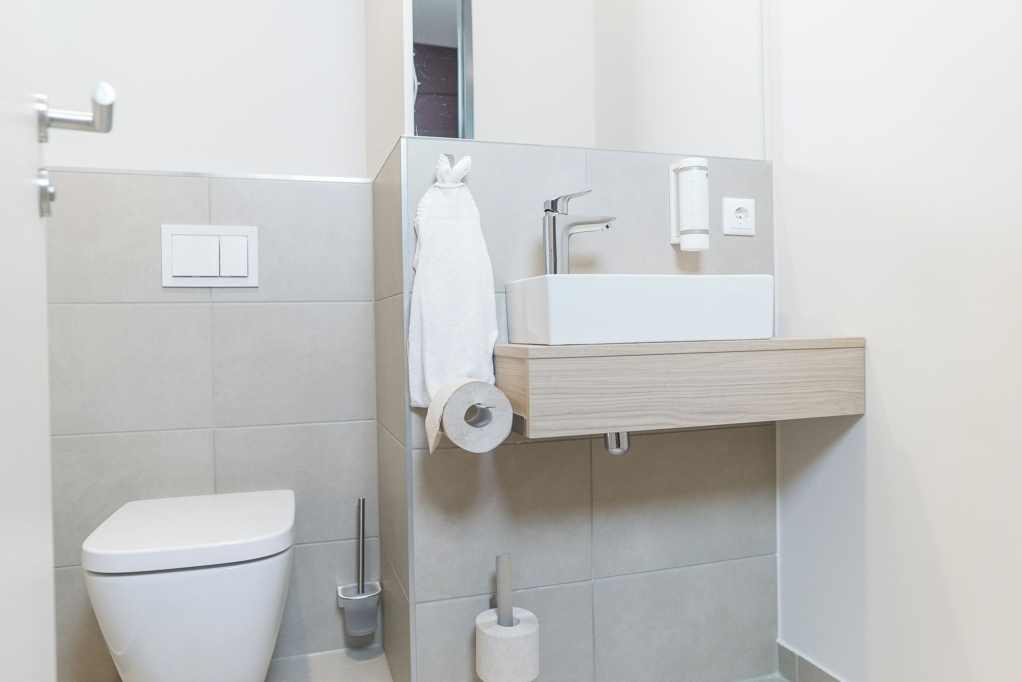 A modern bathroom with a toilet, a sink, and a shower.