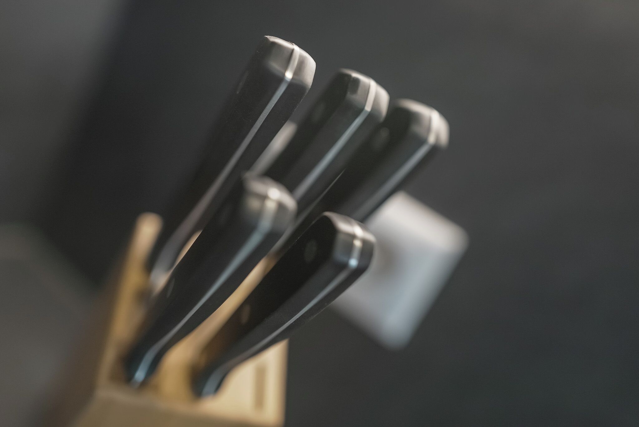 A set of knives in a wooden holder.