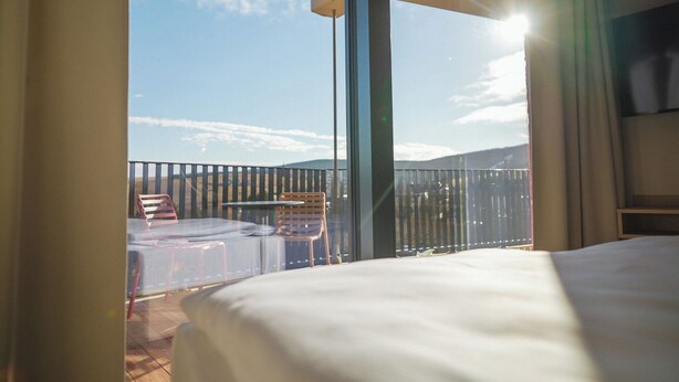 Un balcon avec un lit, une table et des chaises.