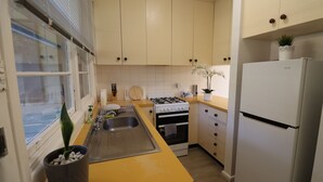 A kitchen with yellow countertops, a sink, a stove, an oven, and a refrigerator. - Humble Abode near Train Station, Costco, Eastland (Heathmont)
