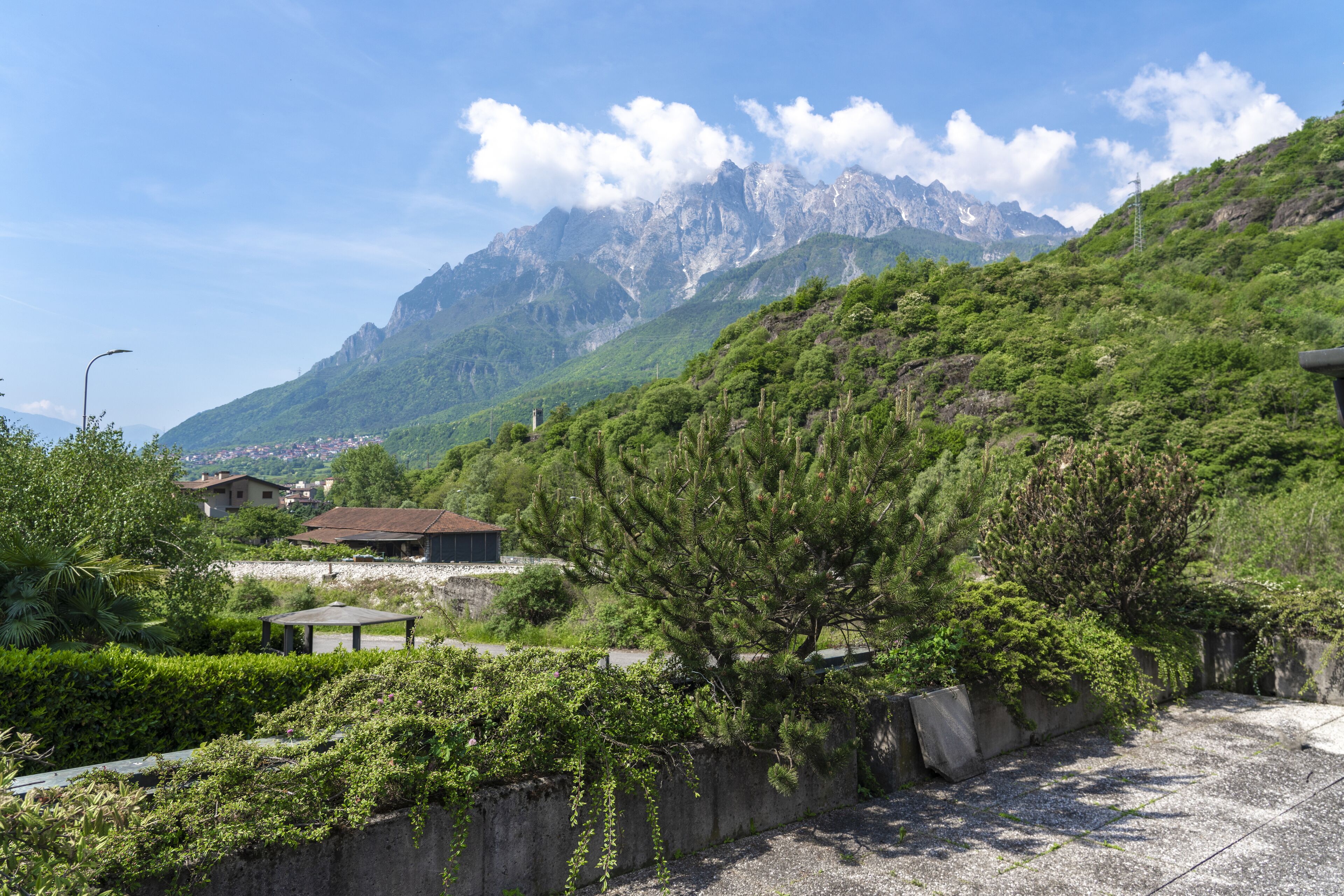A mountainous landscape with a house and a gazebo.