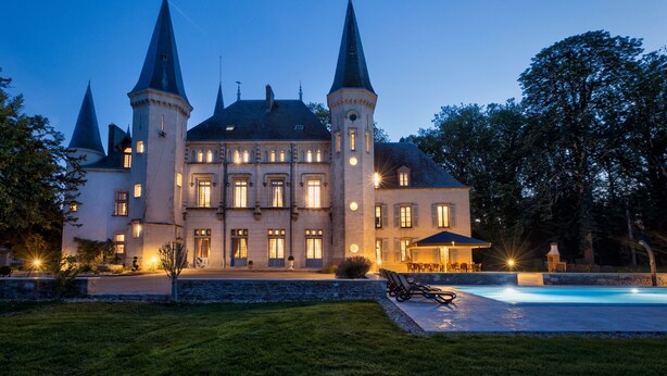 Un grand bâtiment historique doté de nombreuses tours et d’une piscine.