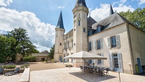 Un bâtiment historique doté de deux tours imposantes, d’une cour avec des espaces de repos en plein air et d’un jardin bien entretenu.