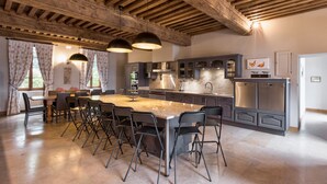 Une cuisine moderne dotée d’un îlot central, de tabourets de bar et d’un coin repas avec une table et des chaises.