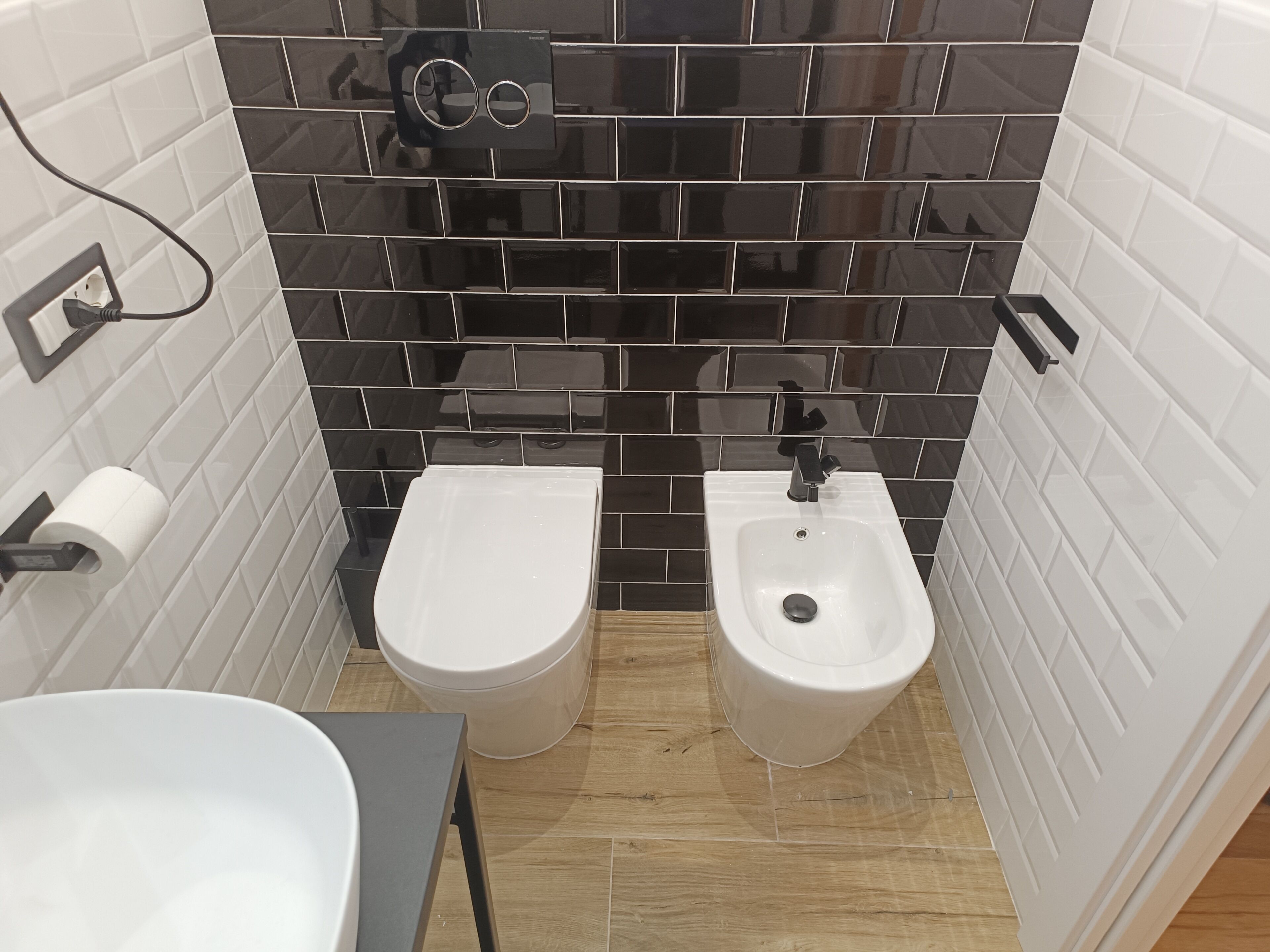 Un bagno piccolo con WC, bidet e lavandino.