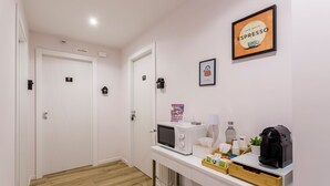 Une cuisine moderne équipée d’un four à micro-ondes, d’une machine à café et d’une tasse à café posée sur le comptoir.