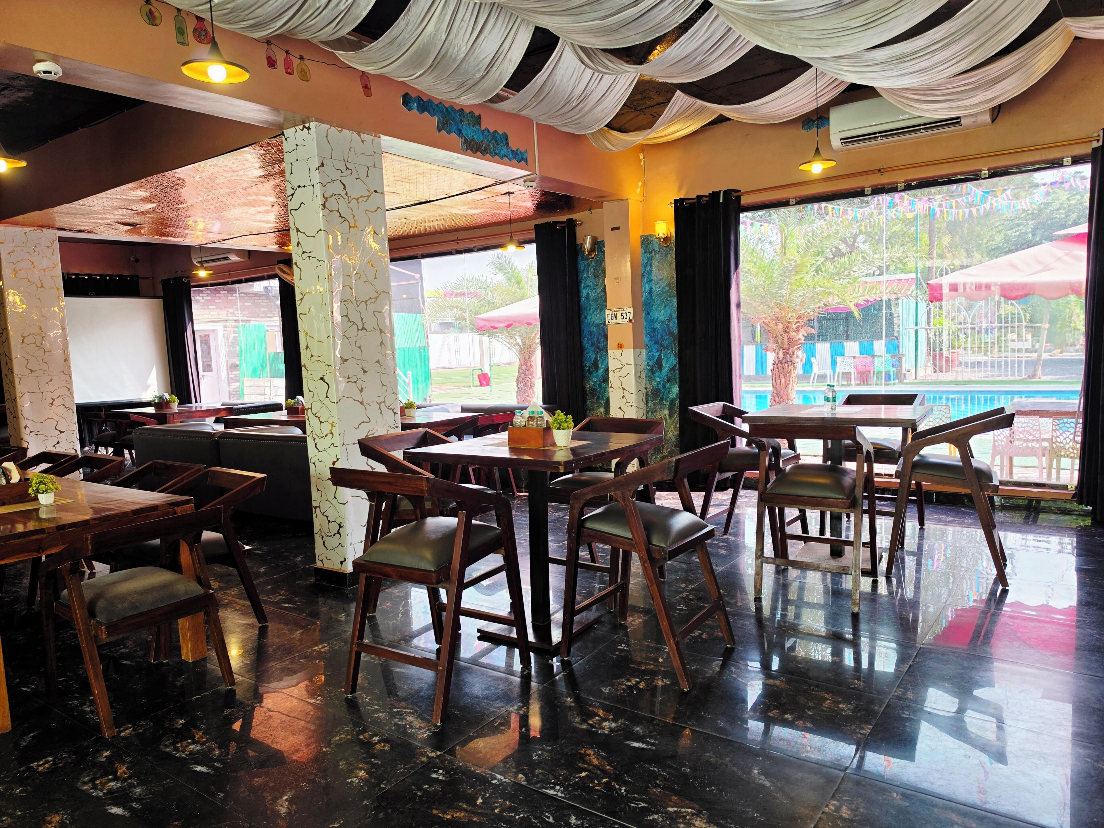 A restaurant interior with tables, chairs, and a view of the outside.