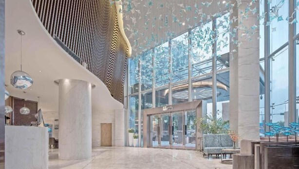 A spacious lobby with a modern design, featuring a large reception desk, seating area, and large windows allowing natural light. - deluxe king (Shenzhen)