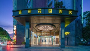 A hotel entrance with a large illuminated sign in yellow characters, a circular skylight above the entrance, and a modern building facade. - deluxe king (Shenzhen)