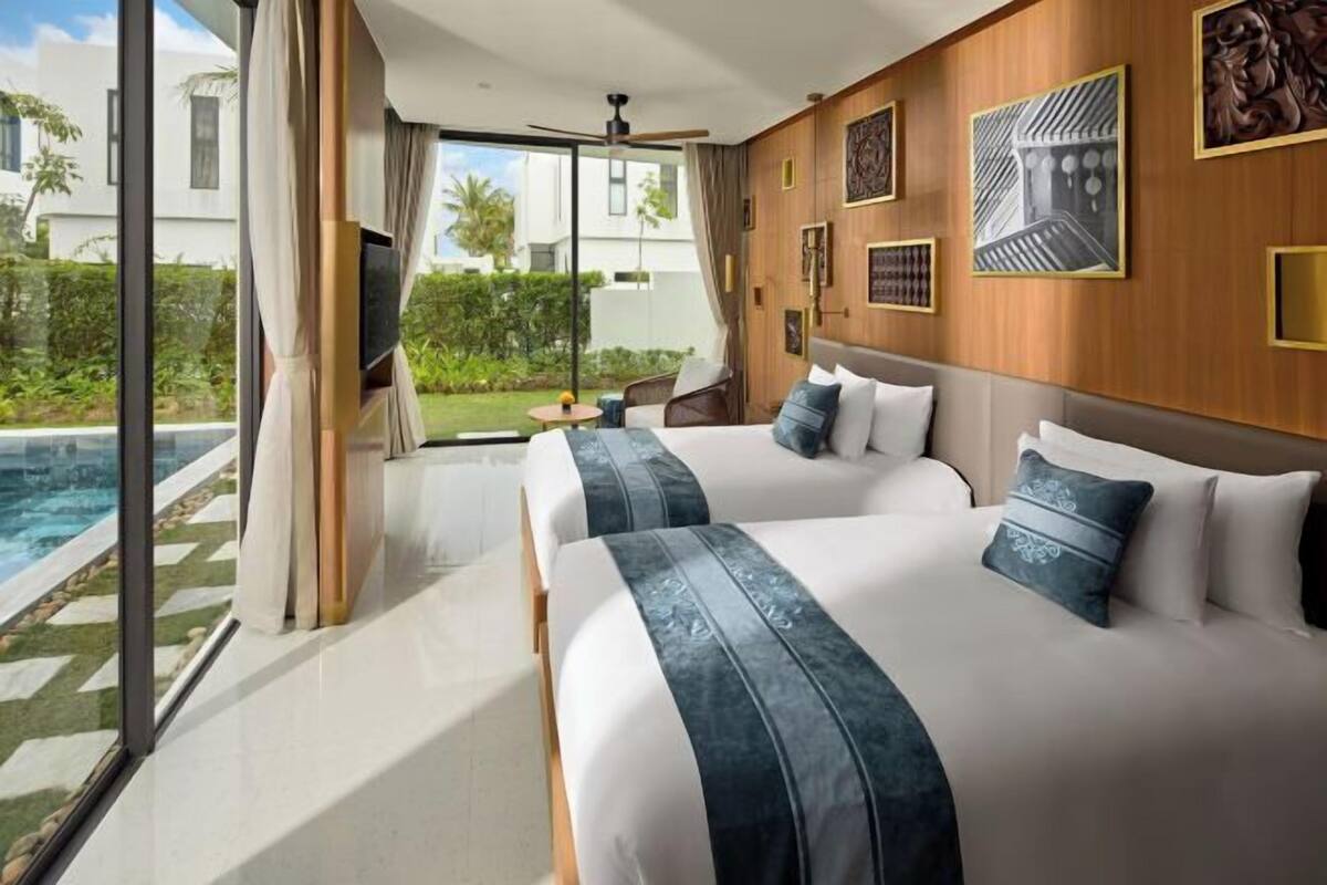 A modern hotel room with two beds, a large window, a ceiling fan, and a view of a swimming pool.