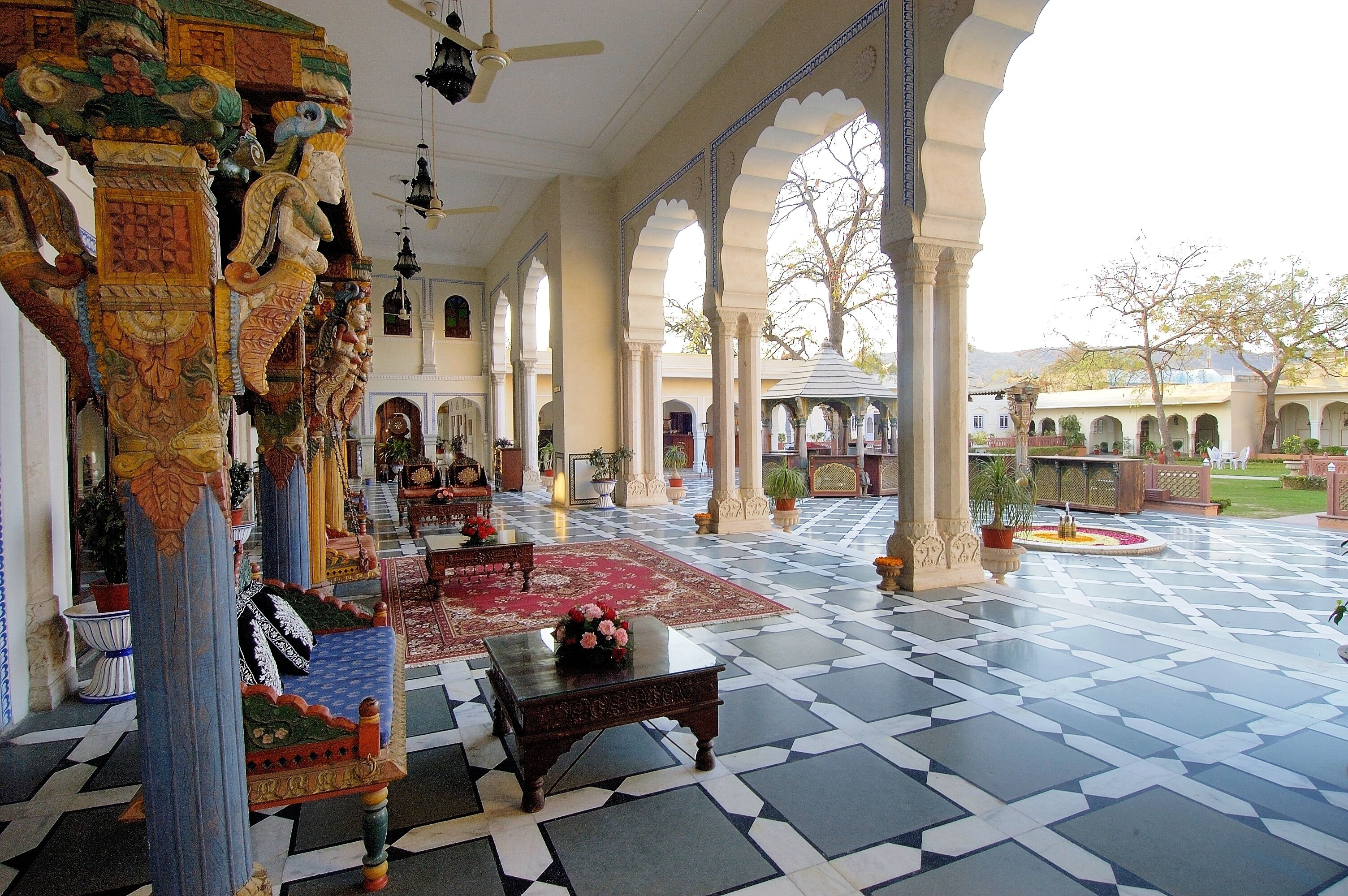 A spacious lobby with ornate columns, a patterned floor, and a view of the surrounding area.