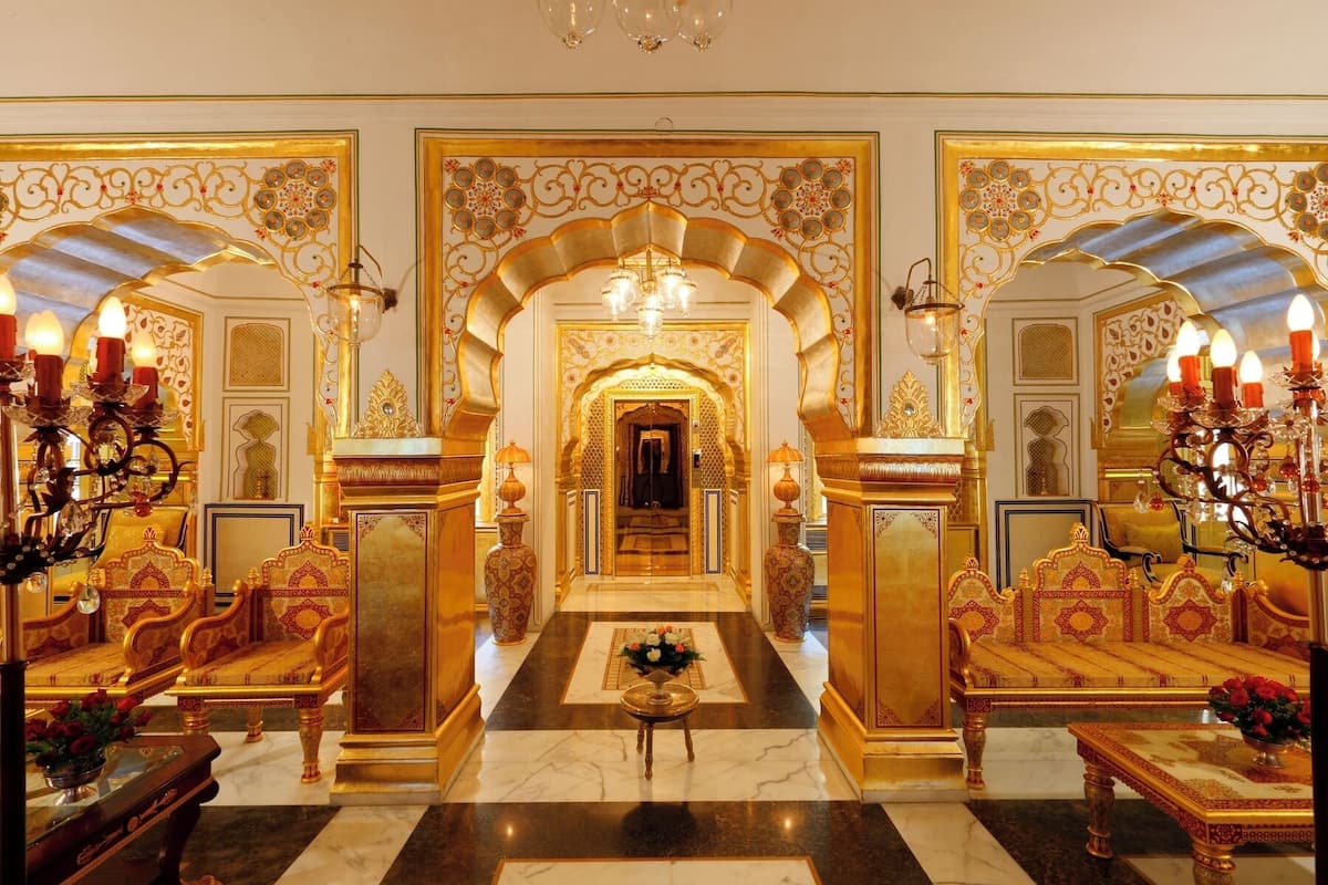 A luxurious interior with ornate golden arches, a grand chandelier, and opulent furnishings.
