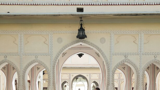 Una piscina interior con arcos decorativos y suelo de baldosas.