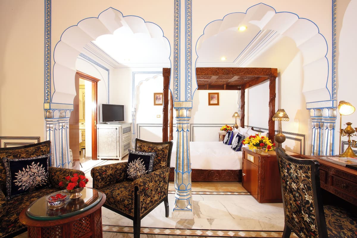 A traditional room with a sofa, armchair, and a table with a vase of flowers.