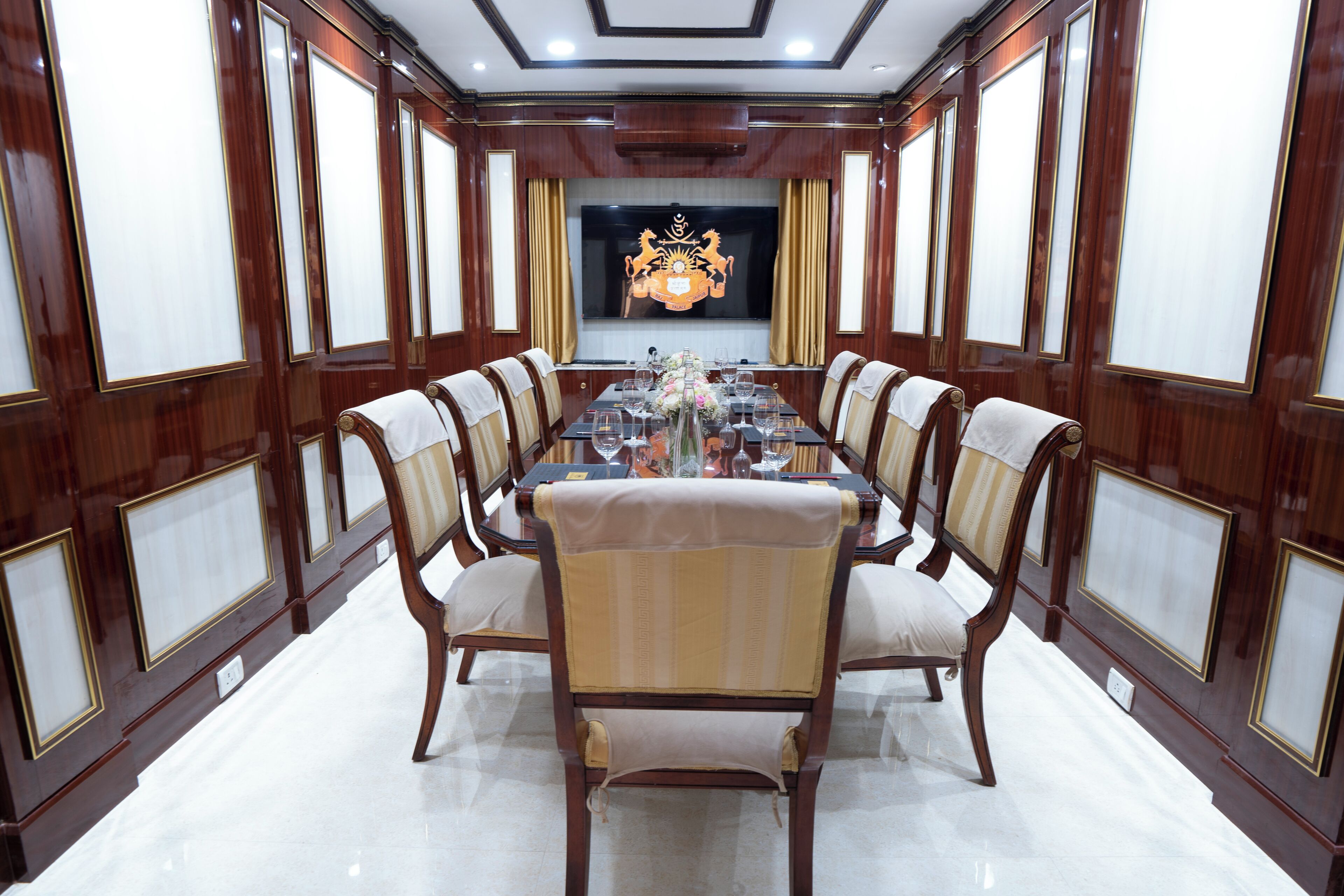 A formal dining room with a long table, six chairs, and a decorative centerpiece.