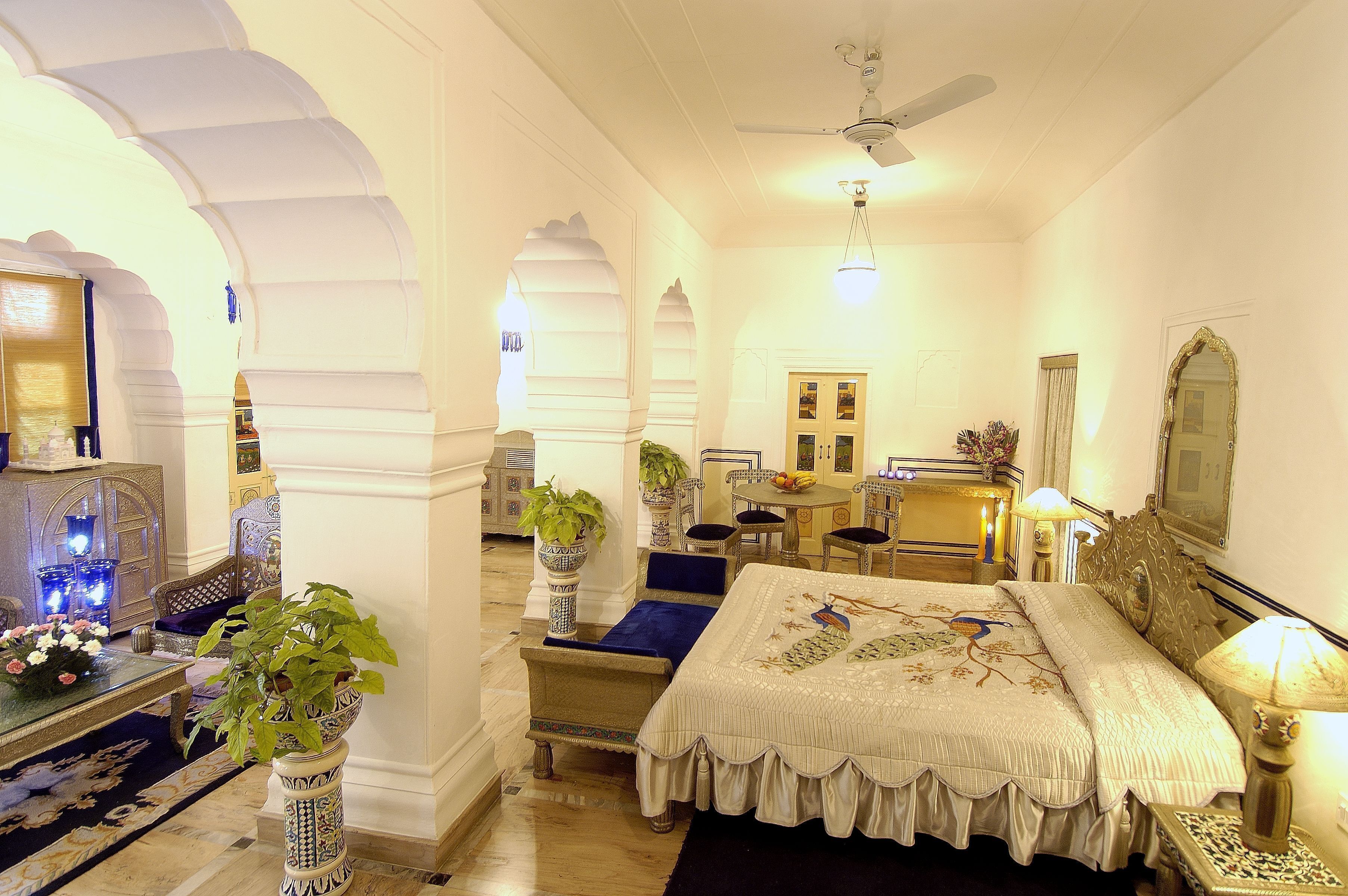 A traditional room with a bed, seating area, and a dining table.