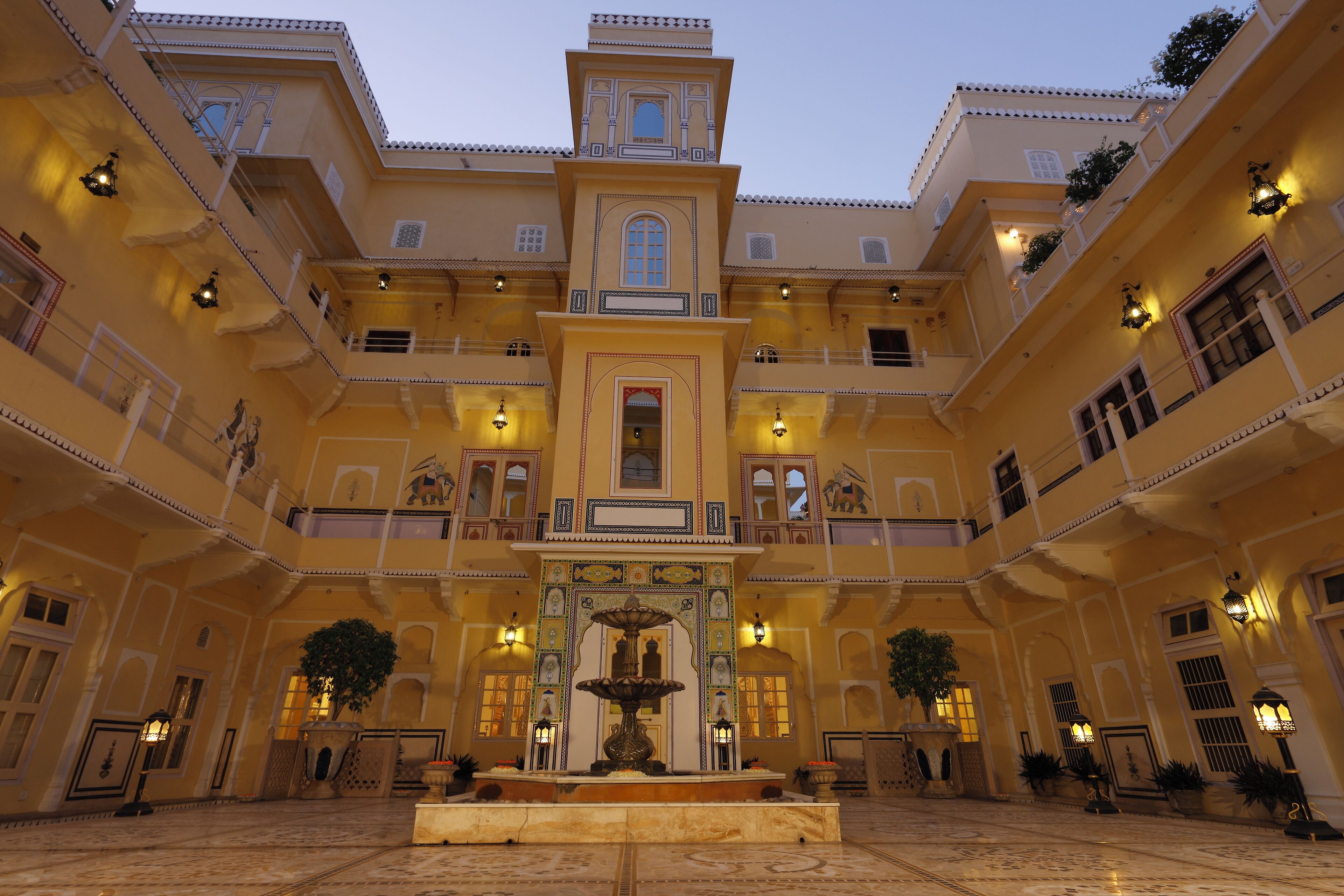 A spacious courtyard with a central fountain, multiple balconies, and traditional architectural details.
