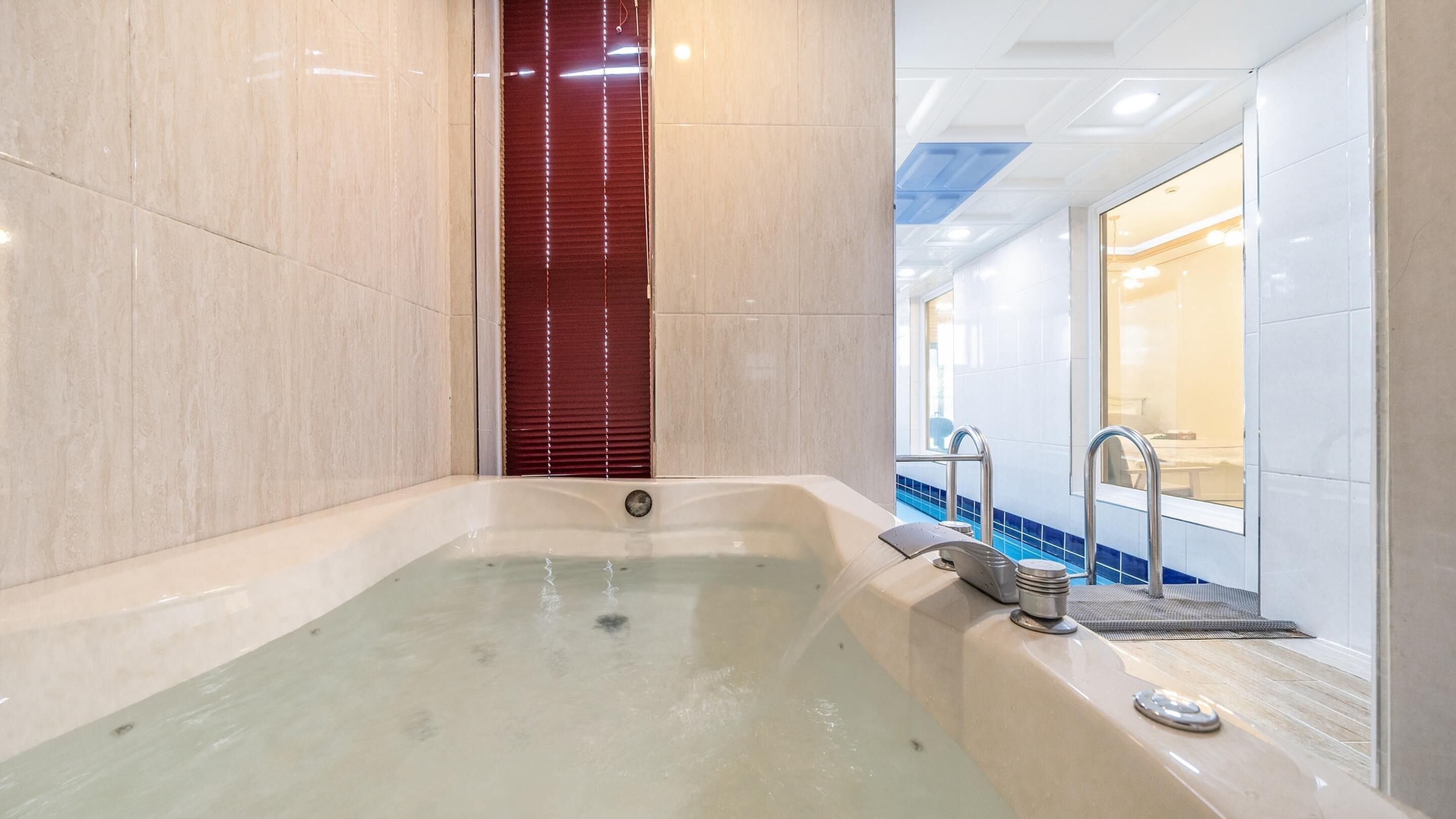 Une salle de bain moderne équipée d’une baignoire, d’une zone de douche et d’un meuble-lavabo avec un miroir.
