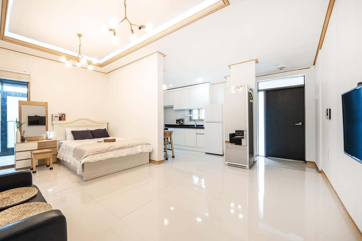 Un dormitorio moderno con cama, mesita de noche y un amplio ventanal.