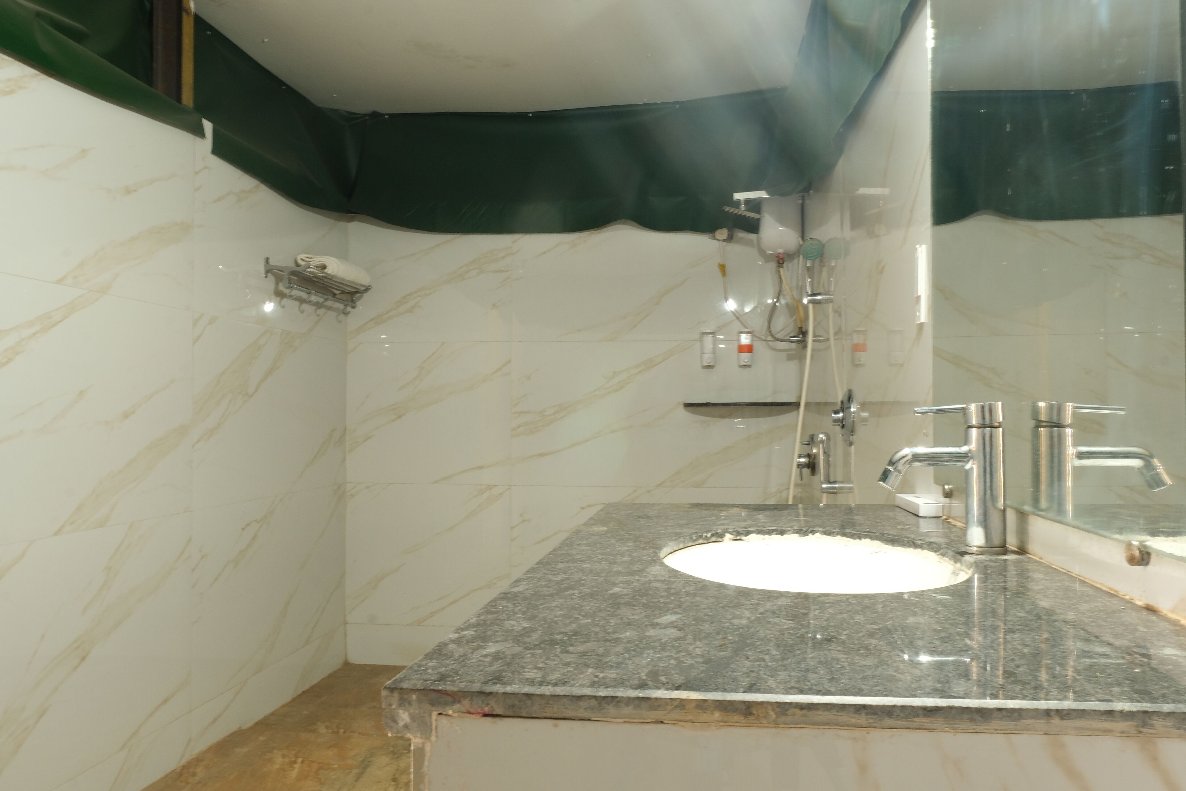A bathroom with a marble sink, a mirror, and a shower.