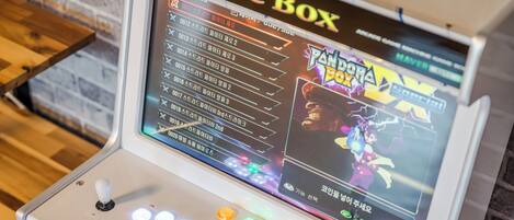 Eine Game Box Spielkonsole mit Bildschirm, der Spieloptionen anzeigt, und einem Joystick-Bedienfeld.