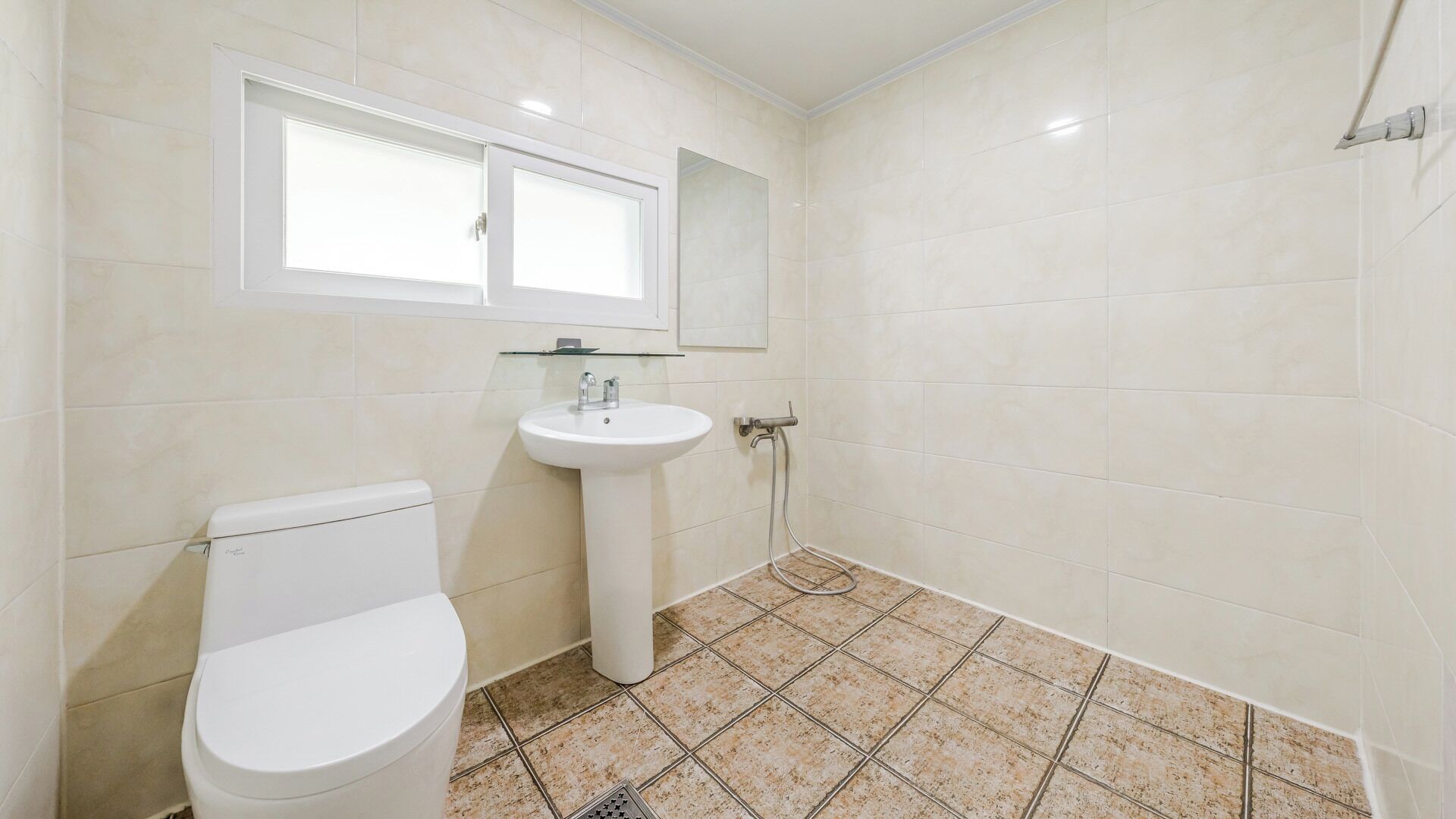 Un baño con inodoro, lavamanos y ducha.