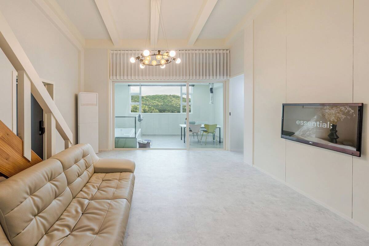 Ein modernes Interieur mit einer Couch, einer Treppe, einer Kristallleuchtre und einem Fernseher, der das Wort 'wichtig' anzeigt.