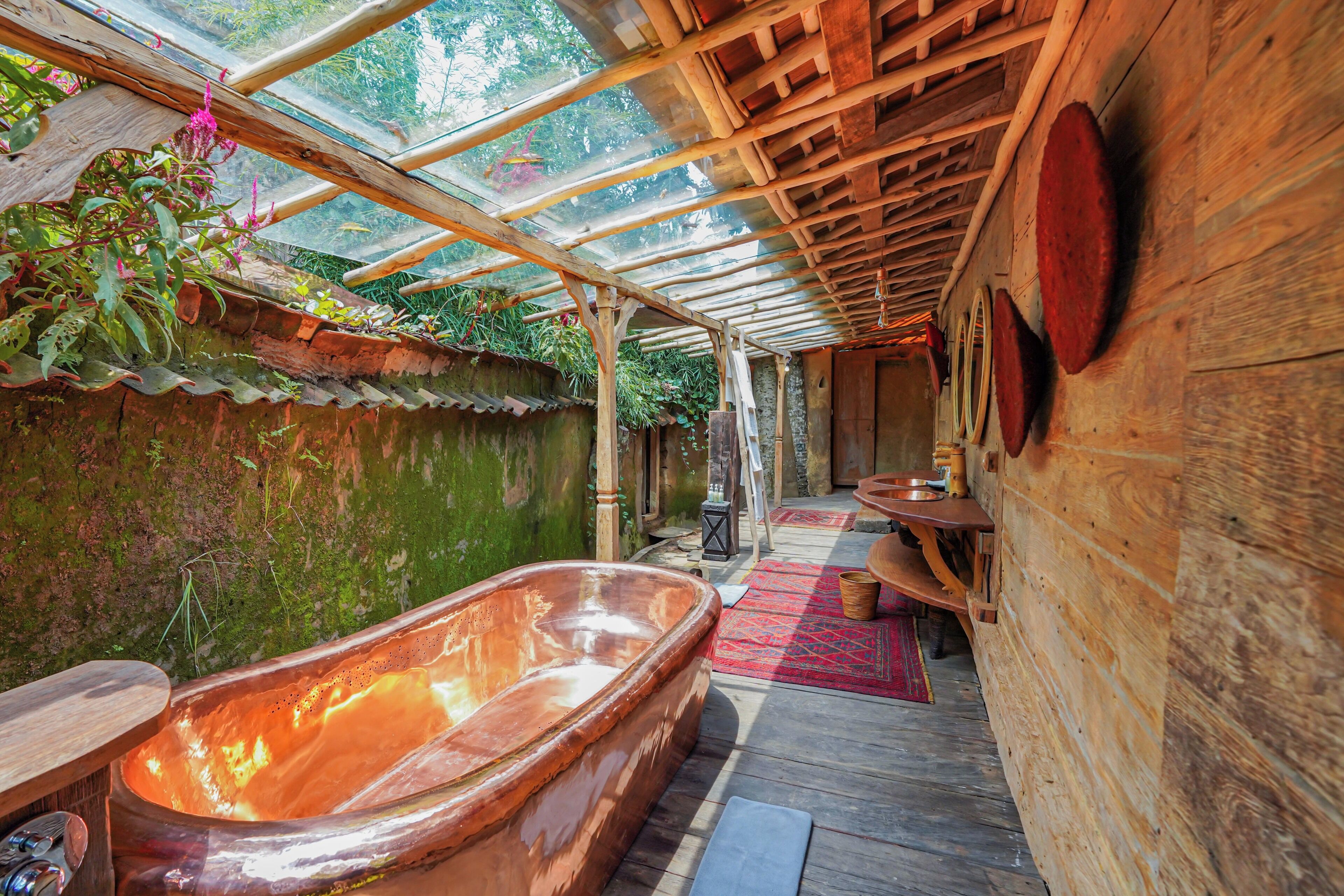 A wooden spa area with a hot tub, wooden benches, and a glass ceiling.