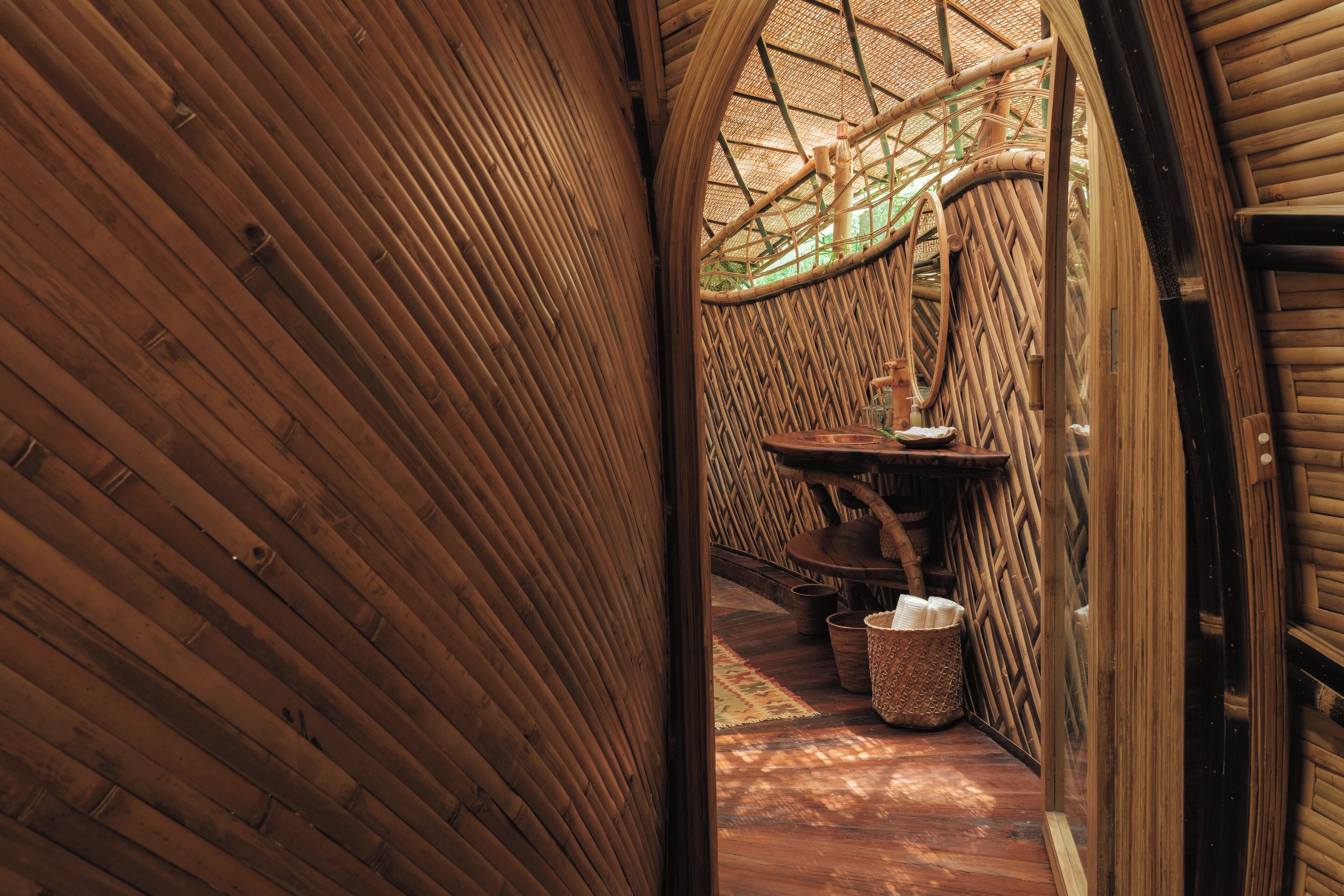 Interior de madera con techo curvo y estructura de pared tejida.