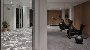 A modern gym with exercise equipment, a staff room, and a marble floor. - Nur Outline Aparthotel (Athens)