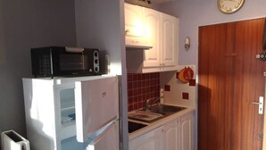 A compact kitchen with white cabinets, a microwave, a toaster, and a sink. - Studio Balaruc LES Bains Proche Cure ET Plage (Balaruc-les-Bains)
