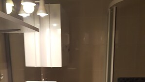 A bathroom with a sink, mirror, and shower. - Studio Balaruc LES Bains Proche Cure ET Plage (Balaruc-les-Bains)