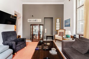 A living room with two sofas, a coffee table, a cabinet with glass doors, and artwork on the walls. - Acropolis Masterpiece Neoclassical Mansion (Athina)