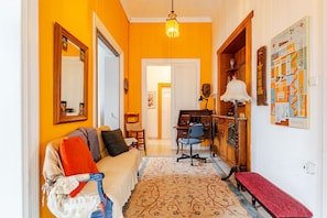 A hallway with a sofa, a desk, and a chair. There is a rug on the floor. - Acropolis Masterpiece Neoclassical Mansion (Athina)