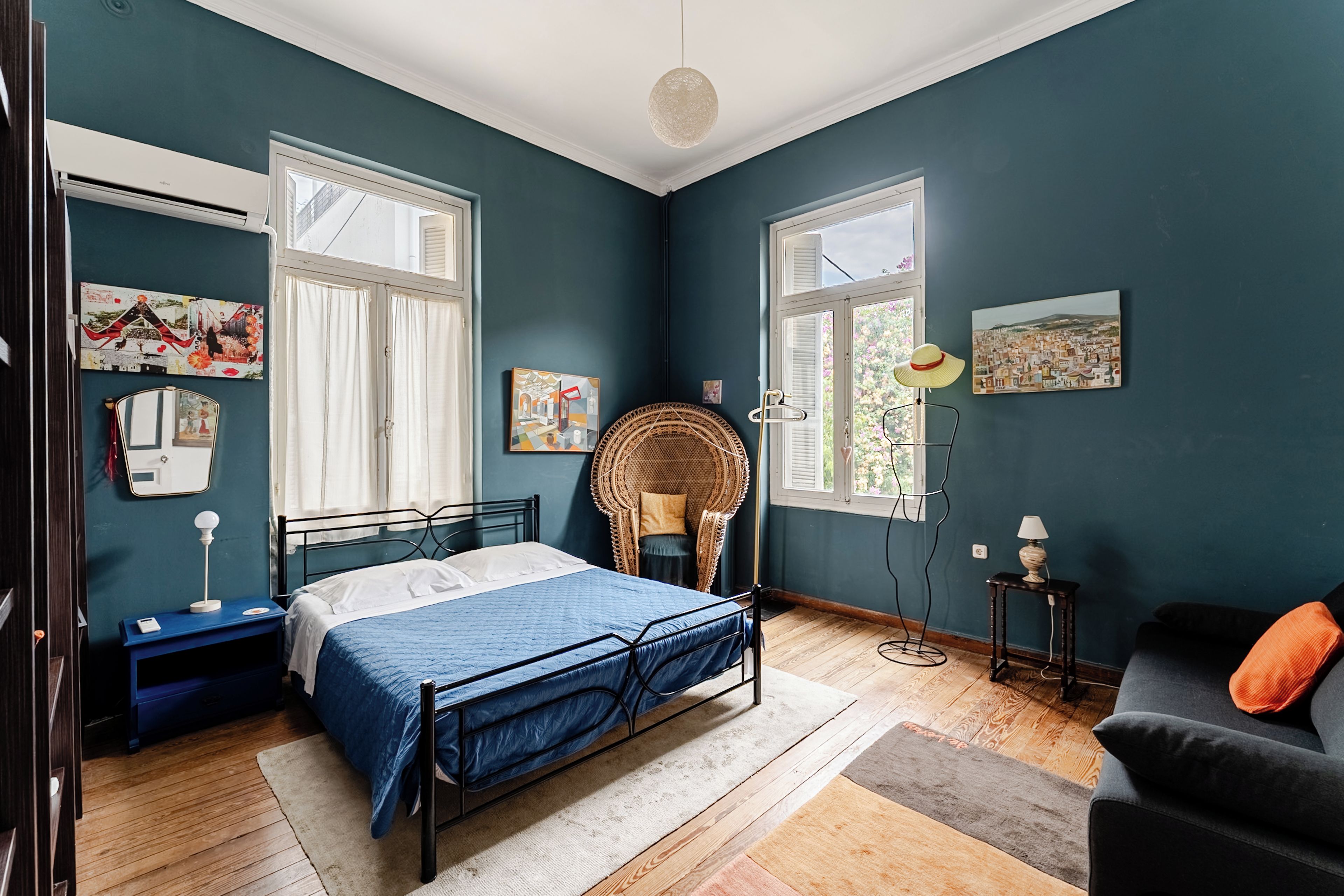 A bedroom with a bed, a chair, a desk, and a window.