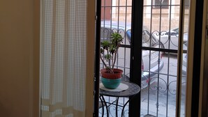 A balcony with a potted plant, a small table, and a chair. - Casa Manzoni, renovated apartment within walking distance of the sea in Bisceglie.   (Bisceglie)
