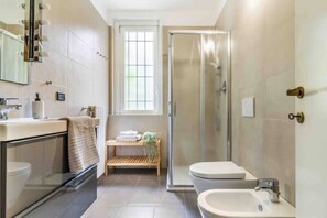 Een douche, een haardroger, een bidet, handdoeken