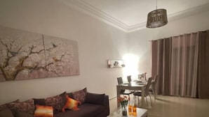 A living room with a dark brown sofa, a coffee table, and a painting on the wall.
