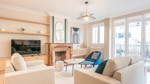 Un salon avec une cheminée, un téléviseur et un balcon offrant une vue agréable.