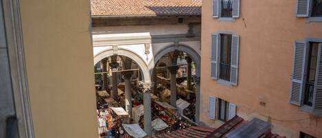 An interior courtyard with arches, tiled roofs, and a view of the street below.