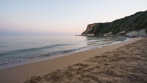 Una playa con arena y un acantilado.