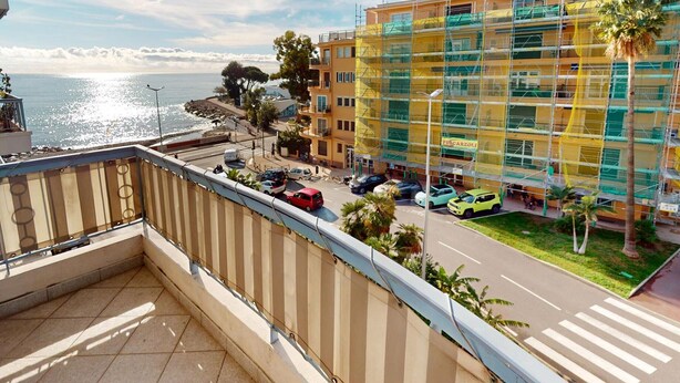 A balcony with a view of a coastal street, a building under construction, and a clear sky. - Cozy 3P with air conditioning and balcony, near beaches (Menton)