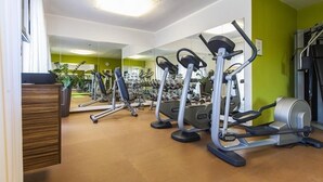 Un gimnasio con cintas de correr, elípticas y máquinas de pesas.